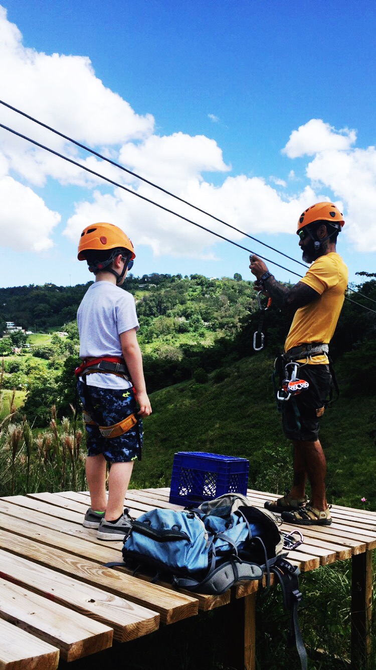 seven year old ziplining over the rainforest in puerto rico